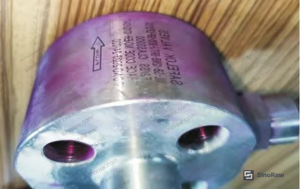 Figure 3: Macro photograph of valve body showing penetrant test indications — six crack locations concentrated on flange weld side, post-processing developer and penetrant residues visible