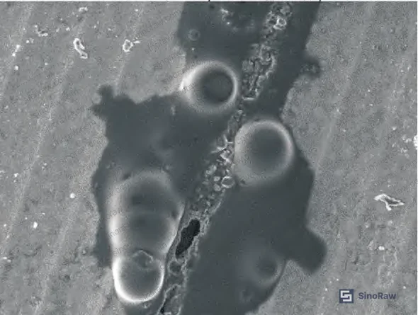 Figure 8: SEM image of crack region adjacent to flange bolt hole — crack edges rounded, crack width increases approaching bolt hole, blocky oxide masses covering right-side crack